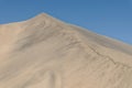 A sculptured sand ridge with little sand avalanches running down from the top