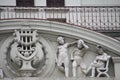 sculptures on the exterior of a building at an angle overlooking a window Royalty Free Stock Photo