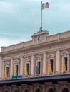 Sculptures of Yellow and Gray Wolves Leaning Against the Outside of Large Windows in Parma Central Train Station and Italian Flag