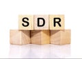 SDR text on wooden cubes on a white background