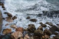 Seascape, seafoam of storm on wild rocky seashore