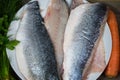 Sea bass filet with ingredients on wooden board