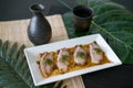 Sea bass sashimi with sauce on white plate, black decanter with sake Royalty Free Stock Photo
