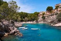 Sea bay a beautiful summer day blue clear water and granite stones. Boats above coral reef. Spain. Royalty Free Stock Photo