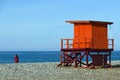 Sea beach with a bright lifeguard tower and a couple near the water. Royalty Free Stock Photo