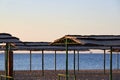 Sea beach at sunrise, thatched canopies for shelter from the sun