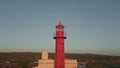 Sea beacon placed coast under beautiful evening sky drone view. Red lighthouse Royalty Free Stock Photo