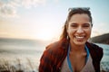 By the sea is a beautiful place to be. Portrait of a happy young woman enjoying the beach at sunset. Royalty Free Stock Photo