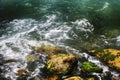 Sea, beautiful sea surf, seascape. Green sea water, waves, splashes, stones, white foam on the water and green moss on the stones Royalty Free Stock Photo