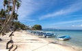 Sea, blue sky, palms and boats in White beach, Sabang, Puerto Galera, Philippines. Popular tourist and diving spot. Royalty Free Stock Photo