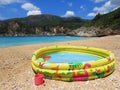 Sea blue waves and inflatable pool for kids in summer on the beach. Vacation and travel.