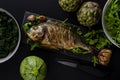 Sea bream or dorada fish baked in oven on black Royalty Free Stock Photo