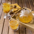 Sea buck thorn tea with orange, napkin and nuts at wooden background