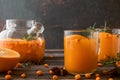 Sea buckthorn autumn tea with orange in glass cups with fresh berries, cinnamon and rosemary. Herbal vitamin tea