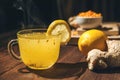 Sea buckthorn tea on a dark wooden textural background toned. Sea buckthorn, ginger, books in the background, the concept of warmt