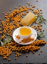 Sea buckthorn, honeycomb with honey and cup of  tea on black stone table Royalty Free Stock Photo