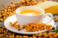 Sea buckthorn, honeycomb with honey and cup of tea on black Royalty Free Stock Photo