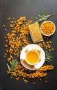 Sea buckthorn, honeycomb with honey and cup of  tea on black table Royalty Free Stock Photo