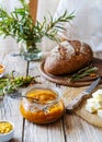 Sea buckthorn jam in a glass jar with butter, fresh berries, leaves and loaf bread Royalty Free Stock Photo