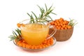 Sea buckthorn tea in a glass and wooden bowl with berries isolated on white background