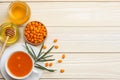 Sea buckthorn in wooden bowl, honey, Sea buckthorn juice on wooden table. top view with copy space Royalty Free Stock Photo