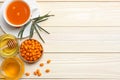 Sea buckthorn in wooden bowl, honey, Sea buckthorn juice on wooden table. top view with copy space Royalty Free Stock Photo