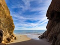 Sea from the cave entrance with rocks at sand ocean beach Royalty Free Stock Photo