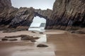 sea cave framed by rock arch at low tide Royalty Free Stock Photo