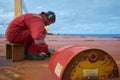 At sea - Circa October 2018: Sailors cutting old D-rings at open deck of a ship. Ship maintenance concept