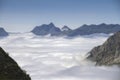 A sea of clouds runs through a glacial valley surrounded by high mountains Royalty Free Stock Photo