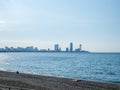 Sea coast against the backdrop of the city. Few people on the beach. Rocky shore of the Black Sea. Seaside holiday concept. Batumi Royalty Free Stock Photo