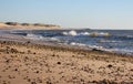 Sea coast with beach full of pebbles. Seashore with surf waves. Empty sand beach. Dramatic coastline.