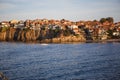 The sea coast of Bulgaria is a sandy beach with Golden sand and rocky high banks with tiled roofs of houses.