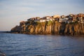 The sea coast of Bulgaria is a sandy beach with Golden sand and rocky high banks with tiled roofs of houses.