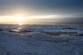 Sea coast covered with broken ice floes in the golden rays of the evening sun Royalty Free Stock Photo
