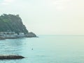 The sea coast in the early morning in a blue haze, a view of the horizon, a stone pier and a mountain Royalty Free Stock Photo