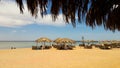 Sea coast with thatched umbrellas on a sandy beach. Seascape on the beach at the end of the holiday season. A great place to relax Royalty Free Stock Photo