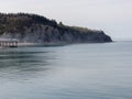 A sea coastal strip of land, cloudy weather, a lonely figure of a woman walking along the seashore on a summer day.