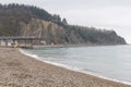 A sea coastal strip of land, cloudy weather, a lonely figure of a woman walking along the seashore on a summer day.