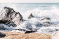 Sea crashing on rocky coast on sunny day Royalty Free Stock Photo