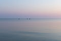 Sea at dawn with three fishing rubber boats, calm.