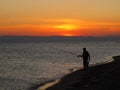 Sea, evening, sunset, fisherman on the beach. Royalty Free Stock Photo