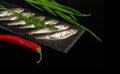 Sea fish sprat with vegetables on a serving board. Small salted fish with onion and pepper Royalty Free Stock Photo