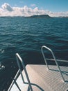 Sea fishing from steel fishing boat on open water. Rocky island et horizon. Royalty Free Stock Photo