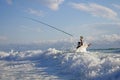 Sea Fishing, surf fishing scene, man fight against the waves Royalty Free Stock Photo