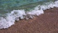 Sea foam and clear water flowing to beach sand in sea surf Royalty Free Stock Photo