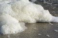 Sea foam on a sand tropical beach. Travel and tourism, bubbles and macro waves Royalty Free Stock Photo