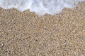 Sea foamy wave on a pebble beach top view Royalty Free Stock Photo