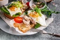 Sea food sandwich. Cod liver, fresh lettuce, pea sprouts, tomatoes and fried eggs. Healty and tasty breakfast on a cutting wooden