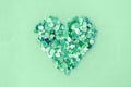 sea glass pieces in the shape of a heart on mint background Royalty Free Stock Photo